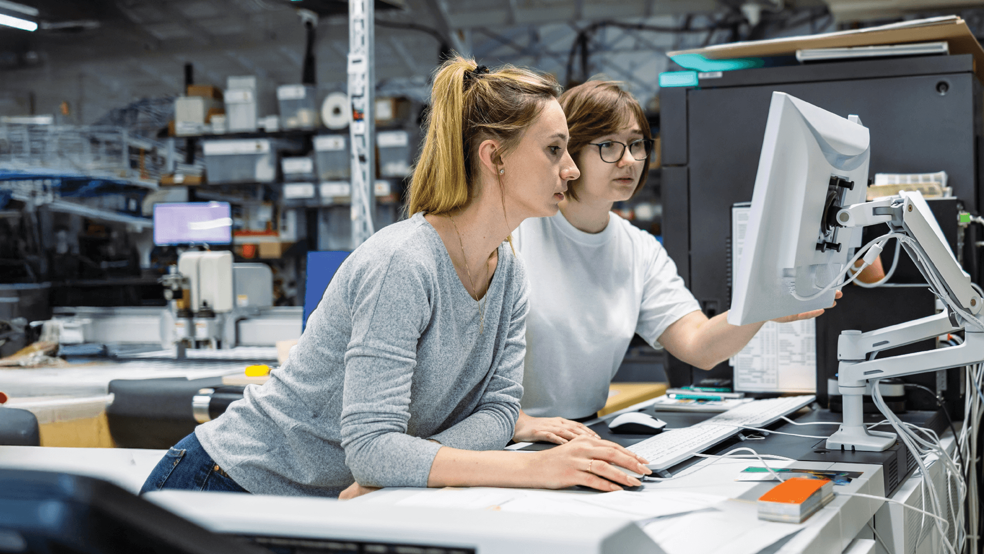 Print shop workers looking at computer