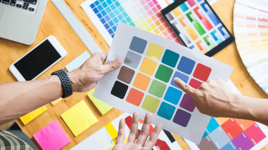 Two designers looking over a paper with different colors blocks on it