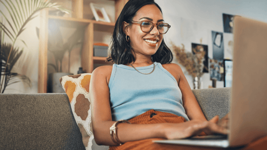 woman of color working on a laptop on a couch