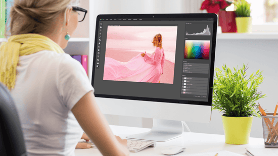 woman working sitting at a desk working at a iMac