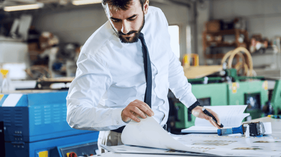 man looking at plans on a table